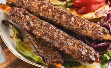 Türk mutfağının en köklü yemeklerinden biri olan Kebap, yalnızca Türkiye’de değil dünyanın birçok ülkesinde büyük ilgi gören özel bir lezzet olarak bilinir. Yüzyıllardır Anadolu, Orta Doğu ve Mezopotamya kültürünün etkisiyle gelişen bu yemek, farklı pişirme teknikleri ve yöresel tariflerle günümüze kadar ulaşmıştır. Özellikle etin odun ateşinde ya da közde pişirilmesiyle hazırlanan Kebap, kendine özgü aroması sayesinde dünya gastronomisinde önemli bir yere sahiptir. Konulu bir haber görseli.