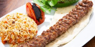 Türkiye’nin en köklü yemek kültürlerinden biri olan Urfa Kebap, kendine özgü aroması ve pişirme tekniğiyle kebap çeşitleri arasında özel bir yere sahip bulunuyor. Güneydoğu Anadolu mutfağının önemli temsilcilerinden biri olan bu lezzet, özellikle baharat dengesi ve etin doğal tadını ön plana çıkaran yapısıyla dikkat çekiyor. Acı oranının daha düşük olması nedeniyle geniş bir damak zevkine hitap eden Urfa Kebap, yıllardır hem yerel halkın hem de turistlerin yoğun ilgi gösterdiği yemekler arasında yer alıyor. Konulu bir haber görseli.