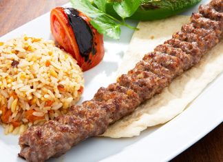 Türkiye’nin en köklü yemek kültürlerinden biri olan Urfa Kebap, kendine özgü aroması ve pişirme tekniğiyle kebap çeşitleri arasında özel bir yere sahip bulunuyor. Güneydoğu Anadolu mutfağının önemli temsilcilerinden biri olan bu lezzet, özellikle baharat dengesi ve etin doğal tadını ön plana çıkaran yapısıyla dikkat çekiyor. Acı oranının daha düşük olması nedeniyle geniş bir damak zevkine hitap eden Urfa Kebap, yıllardır hem yerel halkın hem de turistlerin yoğun ilgi gösterdiği yemekler arasında yer alıyor. Konulu bir haber görseli.