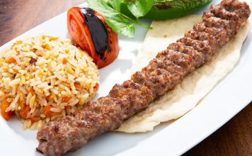 Türkiye’nin en köklü yemek kültürlerinden biri olan Urfa Kebap, kendine özgü aroması ve pişirme tekniğiyle kebap çeşitleri arasında özel bir yere sahip bulunuyor. Güneydoğu Anadolu mutfağının önemli temsilcilerinden biri olan bu lezzet, özellikle baharat dengesi ve etin doğal tadını ön plana çıkaran yapısıyla dikkat çekiyor. Acı oranının daha düşük olması nedeniyle geniş bir damak zevkine hitap eden Urfa Kebap, yıllardır hem yerel halkın hem de turistlerin yoğun ilgi gösterdiği yemekler arasında yer alıyor. Konulu bir haber görseli.