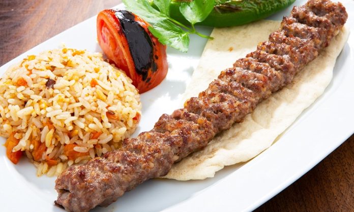Türkiye’nin en köklü yemek kültürlerinden biri olan Urfa Kebap, kendine özgü aroması ve pişirme tekniğiyle kebap çeşitleri arasında özel bir yere sahip bulunuyor. Güneydoğu Anadolu mutfağının önemli temsilcilerinden biri olan bu lezzet, özellikle baharat dengesi ve etin doğal tadını ön plana çıkaran yapısıyla dikkat çekiyor. Acı oranının daha düşük olması nedeniyle geniş bir damak zevkine hitap eden Urfa Kebap, yıllardır hem yerel halkın hem de turistlerin yoğun ilgi gösterdiği yemekler arasında yer alıyor. Konulu bir haber görseli.