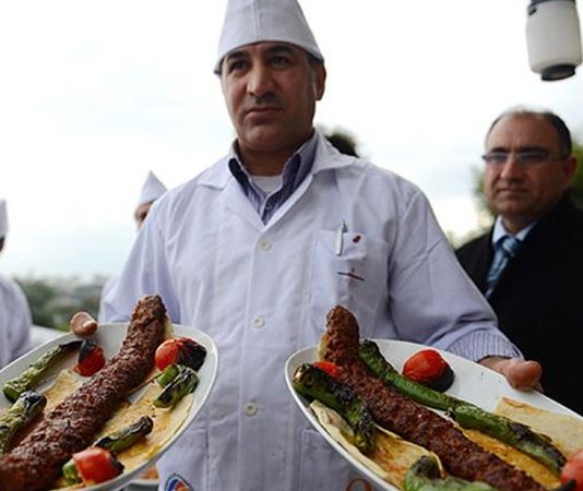 Türk mutfağının en köklü lezzetlerinden biri olan Kebap, yüzyıllardır süregelen ustalık geleneği sayesinde günümüze kadar ulaşmayı başardı. Bu eşsiz lezzetin arkasında ise yıllarını mesleğine adamış, et seçiminden pişirme tekniğine kadar her ayrıntıya hakim olan kebap ustaları bulunuyor. Türkiye'nin farklı bölgelerinde yetişen ustalar, geleneksel yöntemleri korurken aynı zamanda değişen damak zevklerine uyum sağlayarak kebap kültürünün gelişimine katkı sunuyor. Konulu bir haber görseli.