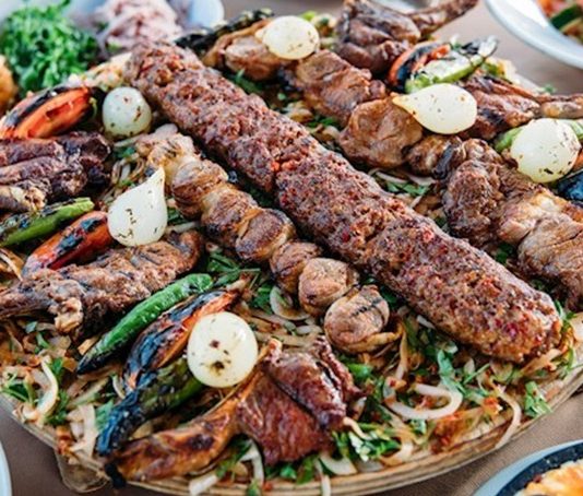 İzmir kebap kültürü, Ege mutfağının hafif ve dengeli gastronomi anlayışıyla birleşerek Türkiye’nin en farklı kebap yorumlarından birini ortaya koyuyor. Geleneksel Anadolu mutfağının güçlü temsilcilerinden olan kebap, İzmir’de daha hafif pişirme teknikleri, farklı sunum anlayışı ve Ege’ye özgü taze malzemelerle yeniden yorumlanıyor. Bu durum şehrin gastronomi kimliğini diğer bölgelerden ayıran önemli bir unsur haline gelmiş durumda. Konulu bir haber görseli.