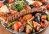 Karışık kebap tabağı, Türk mutfağının en zengin sunumlarından biri olarak hem yerli hem de yabancı misafirlerin en çok tercih ettiği lezzetler arasında yer alıyor. Aynı tabakta birden fazla kebap çeşidini bir araya getiren bu özel sunum, farklı damak tatlarını tek bir öğünde deneyimleme fırsatı sunmasıyla öne çıkıyor. Son yıllarda değişen tüketici beklentileri ve restoranların yenilikçi menü çalışmaları sayesinde karışık kebap tabağı konsepti daha da gelişerek gastronomi sektörünün dikkat çeken trendlerinden biri haline geldi. Konulu bir haber görseli.