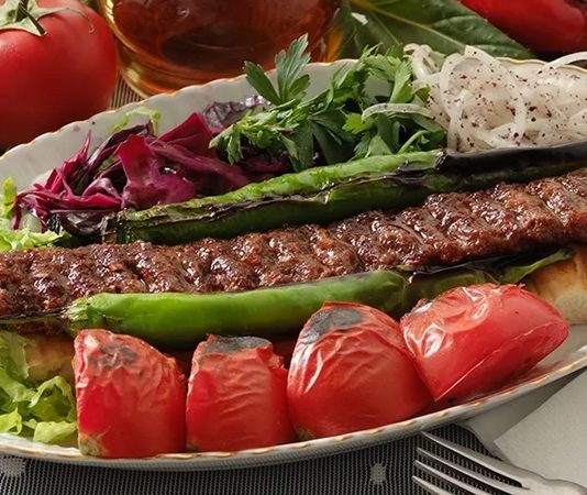 Kebap Servis Hızında Rekabet Restoran sektöründe müşteri memnuniyetini belirleyen en önemli unsurlardan biri artık yalnızca lezzet değil, aynı zamanda servis hızı olarak öne çıkıyor. Özellikle kebap restoranlarında siparişin hazırlanma süresi, sunum kalitesi ve masaya ulaşma hızı işletmeler arasında ciddi bir rekabet alanı oluşturuyor. Günümüzde müşteriler kaliteli ürün kadar kısa bekleme süresini de önemsiyor. Bu nedenle birçok işletme mutfak organizasyonunu yeniden düzenleyerek daha hızlı hizmet sunmaya odaklanıyor. Konulu bir haber görseli.