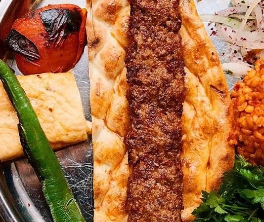 Kebap ve Lavaş Kültürü Kebap ve Lavaş Kültürü, Türk mutfağının en köklü gastronomi geleneklerinden biri olarak nesilden nesile aktarılmaya devam ediyor. Anadolu'nun birçok bölgesinde hazırlanan kebap, yalnızca etin pişirilme yöntemiyle değil, yanında sunulan lavaş ile de tamamlanan bir lezzet olarak öne çıkıyor. İnce yapısı, yumuşak dokusu ve sıcak servis edilmesi sayesinde lavaş, kebap sofralarının vazgeçilmez unsurlarından biri haline gelmiş durumda. Konulu bir haber görseli.