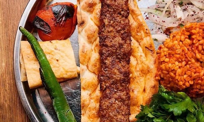 Kebap ve Lavaş Kültürü, Türk mutfağının en köklü gastronomi geleneklerinden biri olarak nesilden nesile aktarılmaya devam ediyor. Anadolu'nun birçok bölgesinde hazırlanan kebap, yalnızca etin pişirilme yöntemiyle değil, yanında sunulan lavaş ile de tamamlanan bir lezzet olarak öne çıkıyor. İnce yapısı, yumuşak dokusu ve sıcak servis edilmesi sayesinde lavaş, kebap sofralarının vazgeçilmez unsurlarından biri haline gelmiş durumda. Konulu bir haber görseli.
