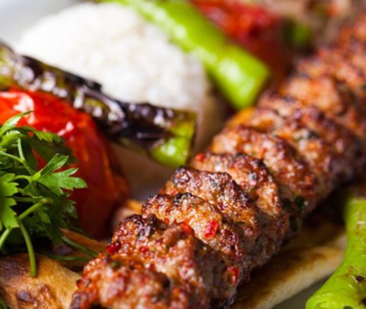 Kebap, Türk mutfağının en sevilen lezzetlerinden biri olarak uzun yıllardır sofralarda önemli bir yere sahip. Geleneksel pişirme teknikleriyle hazırlanan bu özel lezzet, son yıllarda sağlıklı beslenme konusundaki artan farkındalıkla birlikte daha fazla tartışılmaya başlandı. Tüketiciler artık yalnızca lezzeti değil, tükettikleri yiyeceklerin besin değerlerini, hazırlanış yöntemlerini ve içeriklerini de dikkate alıyor. Bu durum, kebap kültürünün modern beslenme anlayışıyla nasıl uyum sağlayabileceği konusunda farklı değerlendirmeleri beraberinde getiriyor. Konulu bir haber görseli.