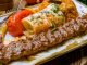 Türkiye’nin en önemli gastronomi değerlerinden biri olan kebap, yalnızca mutfak kültürünün vazgeçilmez bir parçası değil, aynı zamanda turizm ekonomisi açısından da önemli bir gelir kaynağı olarak öne çıkıyor. Yerli ve yabancı turistlerin geleneksel lezzetlere olan ilgisi, kebap restoranlarının yıl boyunca yoğun müşteri ağırlamasını sağlarken şehir ekonomilerine de önemli katkılar sunuyor. Gastronomi odaklı seyahatlerin yaygınlaşmasıyla birlikte kebap, turistik destinasyonların tanıtımında güçlü bir unsur haline gelmiş durumda. Konulu bir haber görseli.