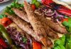 Kebap, Türk mutfağının en köklü lezzetlerinden biri olarak yüzyıllardır farklı bölgelerde çeşitli tariflerle hazırlanıyor. Bu zengin mutfak kültürünün en önemli unsurlarından biri ise baharat kullanımıdır. Baharatlar, yalnızca yemeğin lezzetini artırmakla kalmaz, aynı zamanda kebabın karakterini belirleyen temel unsurlar arasında yer alır. Günümüzde restoranlar, geleneksel tarifleri korurken aynı zamanda modern mutfak anlayışına uygun yeni baharat karışımları geliştirerek kebap çeşitlerini daha geniş bir kitleye ulaştırmayı hedefliyor. Konulu bir haber görseli.