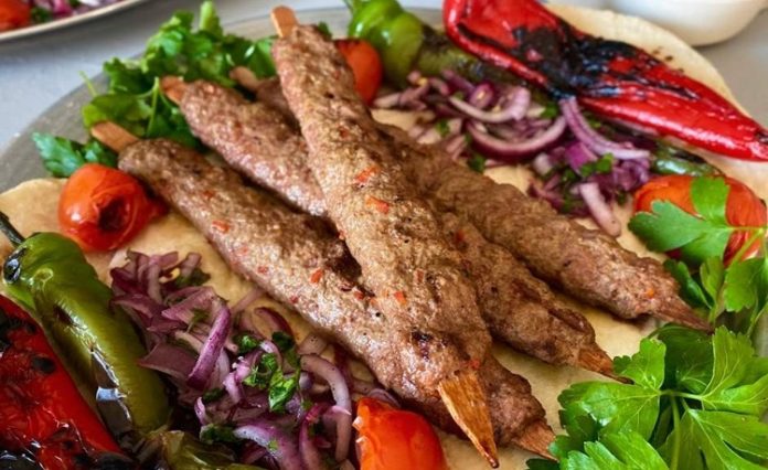 Kebap, Türk mutfağının en köklü lezzetlerinden biri olarak yüzyıllardır farklı bölgelerde çeşitli tariflerle hazırlanıyor. Bu zengin mutfak kültürünün en önemli unsurlarından biri ise baharat kullanımıdır. Baharatlar, yalnızca yemeğin lezzetini artırmakla kalmaz, aynı zamanda kebabın karakterini belirleyen temel unsurlar arasında yer alır. Günümüzde restoranlar, geleneksel tarifleri korurken aynı zamanda modern mutfak anlayışına uygun yeni baharat karışımları geliştirerek kebap çeşitlerini daha geniş bir kitleye ulaştırmayı hedefliyor. Konulu bir haber görseli.