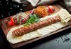 Kebapta Lüks Sunum Deneyimi, son yıllarda gastronomi sektöründe dikkat çeken yeniliklerden biri olarak öne çıkıyor. Geleneksel kebap kültürü, modern sunum anlayışıyla birleşerek restoranlarda farklı bir deneyime dönüşüyor. Artık müşteriler yalnızca lezzetli bir yemek yemekle yetinmiyor; kullanılan tabaklardan servis ekipmanlarına, masa düzeninden sunum tekniklerine kadar her ayrıntının özenle hazırlanmasını bekliyor. Bu değişim, özellikle üst segment restoranlarda hizmet anlayışını yeniden şekillendiriyor. Konulu bir haber görseli.