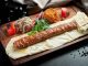 Kebapta Lüks Sunum Deneyimi Kebapta Lüks Sunum Deneyimi, son yıllarda gastronomi sektöründe dikkat çeken yeniliklerden biri olarak öne çıkıyor. Geleneksel kebap kültürü, modern sunum anlayışıyla birleşerek restoranlarda farklı bir deneyime dönüşüyor. Artık müşteriler yalnızca lezzetli bir yemek yemekle yetinmiyor; kullanılan tabaklardan servis ekipmanlarına, masa düzeninden sunum tekniklerine kadar her ayrıntının özenle hazırlanmasını bekliyor. Bu değişim, özellikle üst segment restoranlarda hizmet anlayışını yeniden şekillendiriyor. Konulu bir haber görseli.