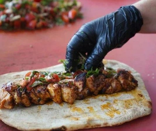 Türkiye’nin köklü gastronomi mirasının önemli parçalarından biri olan Sokak Kebap Kültürü, son yıllarda farklı şehirlerde ve farklı konseptlerde hızla yayılmaya devam ediyor. Geleneksel kebap lezzetini daha ulaşılabilir hale getiren sokak kebapçıları, uygun fiyatları ve hızlı servisiyle geniş bir tüketici kitlesine hitap ediyor. Özellikle büyük şehirlerde artan yoğun yaşam temposu, sokakta sunulan kebap çeşitlerine olan ilgiyi her geçen gün artırıyor. Konulu bir haber görseli.